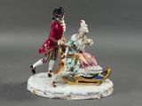 une figurine représentant un homme et une femme sur un traîneau