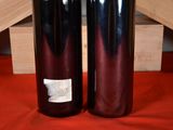 two bottles of wine sitting next to each other on a table