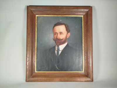 tableau représentant un homme barbu en costume-cravate, dans un cadre en bois