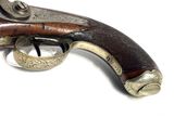 an old gun with a wooden handle on a white surface