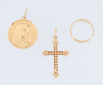 un gros plan d'une croix en or et d'une pièce de monnaie posées sur une surface blanche