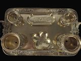 a silver tray that has a bunch of silver objects on it