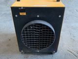 a close up of a yellow and black heater sitting on the ground