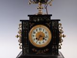 une horloge noire et dorée surmontée d'une couronne