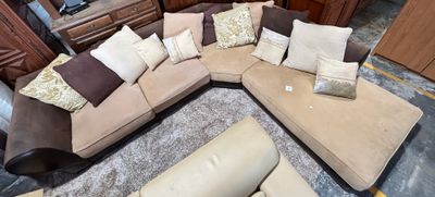 a large sectional couch with pillows on it in a living room