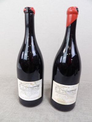 deux bouteilles de vin posées sur une table l'une à côté de l'autre