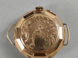 an image of a gold pocket watch sitting on top of a table