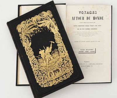 an old book with a gold cover sitting on top of a white table