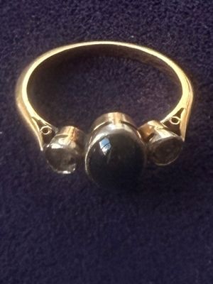 an image of a gold ring with a black stone on it