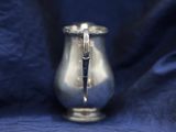 a silver candle that is sitting on a blue cloth