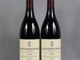 two bottles of wine sitting on top of a table next to each other