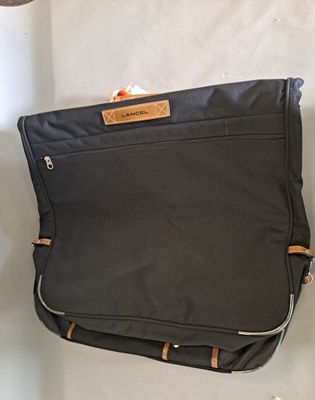 une valise noire posée sur une surface blanche