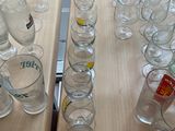 bottles and glasses on a table with a laptop in the background