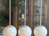 three hanging lights that are on a stand in a room