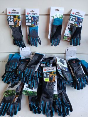 Plusieurs paires de gants de jardinage sont accrochées au mur.