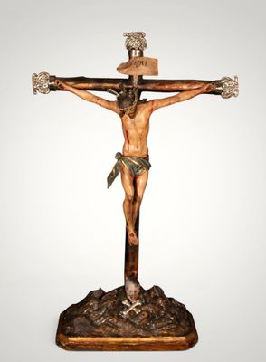 a statue of jesus on the cross with a hat on his head