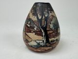 a small vase with a painting on it sitting on a table