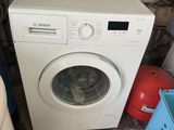 une machine à laver posée dans un coin de la pièce