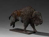 statue of a bison on a wooden base on a gray background