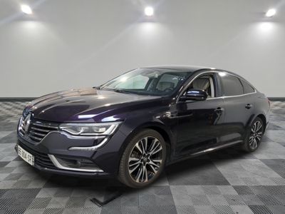 Une voiture de couleur sombre est garée sur un sol en dalles à damier.