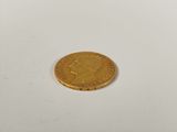 a close up of a gold coin on a white surface