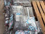many bags of cement sitting on a pallet next to a wooden pallet