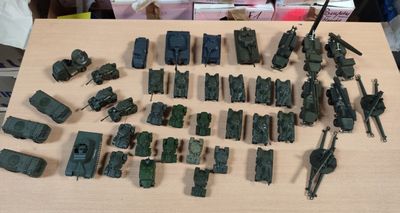 beaucoup de petits véhicules militaires miniatures posés sur une table