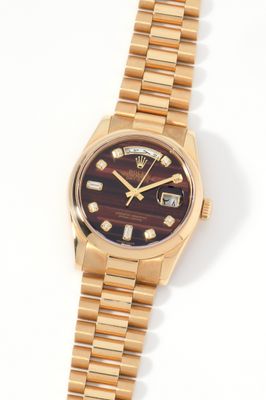 a close up of a watch on a white surface with a white background