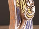 a ceramic sculpture of a woman ' s face on a wooden table