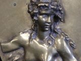 an image of a bronze plaque with a woman holding a bird