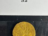 a close up of a gold coin on a black surface