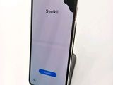 a close up of a phone on a stand on a white surface
