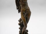 a bronze statue of a woman with a hat on her head