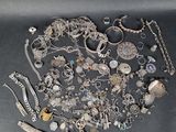 a large collection of silver jewelry on a black surface