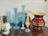 many different vases on a wooden table with a wall in the background