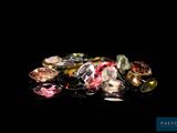 some very pretty colored diamonds on a black surface