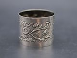a close up of a silver ring with flowers on it