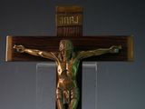 a statue of jesus on a wooden cross with a plaque above it