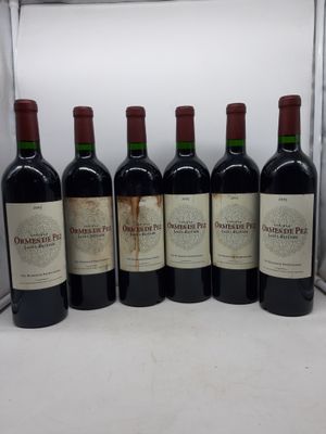 six bouteilles de vin sont alignées sur un comptoir