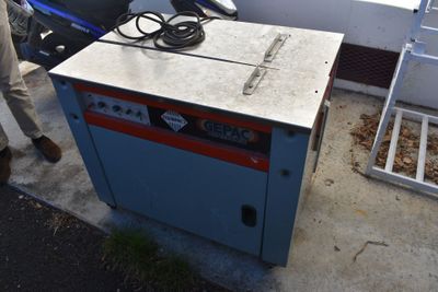 un homme debout à côté d'une machine posée au sol
