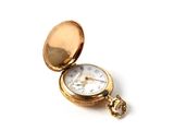 a gold pocket watch sitting on a white surface