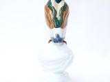 a figurine of a bird sitting on top of a rock