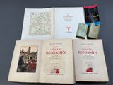 Plusieurs livres sont posés sur une table, avec une carte en arrière-plan.