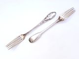 two forks and a spoon on a white surface