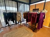 a lot of clothes hanging on a rack in a room