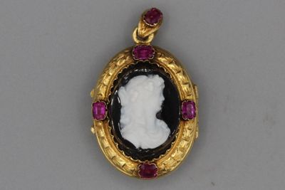 une image représentant un pendentif camée en noir et blanc, orné de rubis tout autour