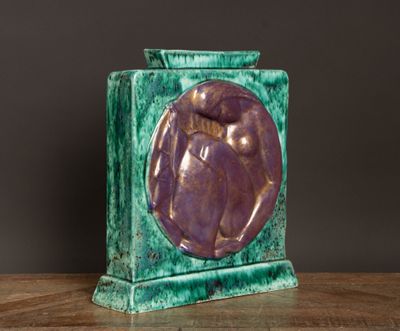 un vase violet et vert posé sur une table en bois