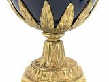 a blue vase on a gold stand on a white background