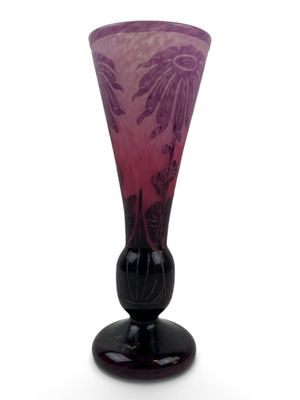 un vase en verre violet avec un socle noir sur fond blanc