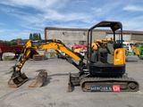 the back end of a small excavator parked in a parking lot